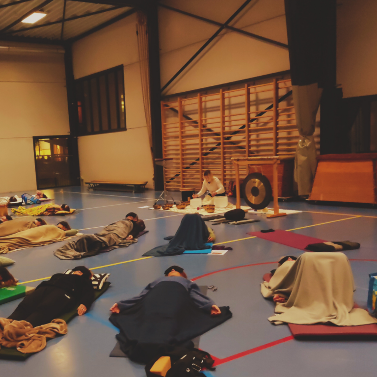 Deelnemer ligt ontspannen in yogahangmat tijdens een Yoga Nidra en Soundhealing sessie in oosterzele